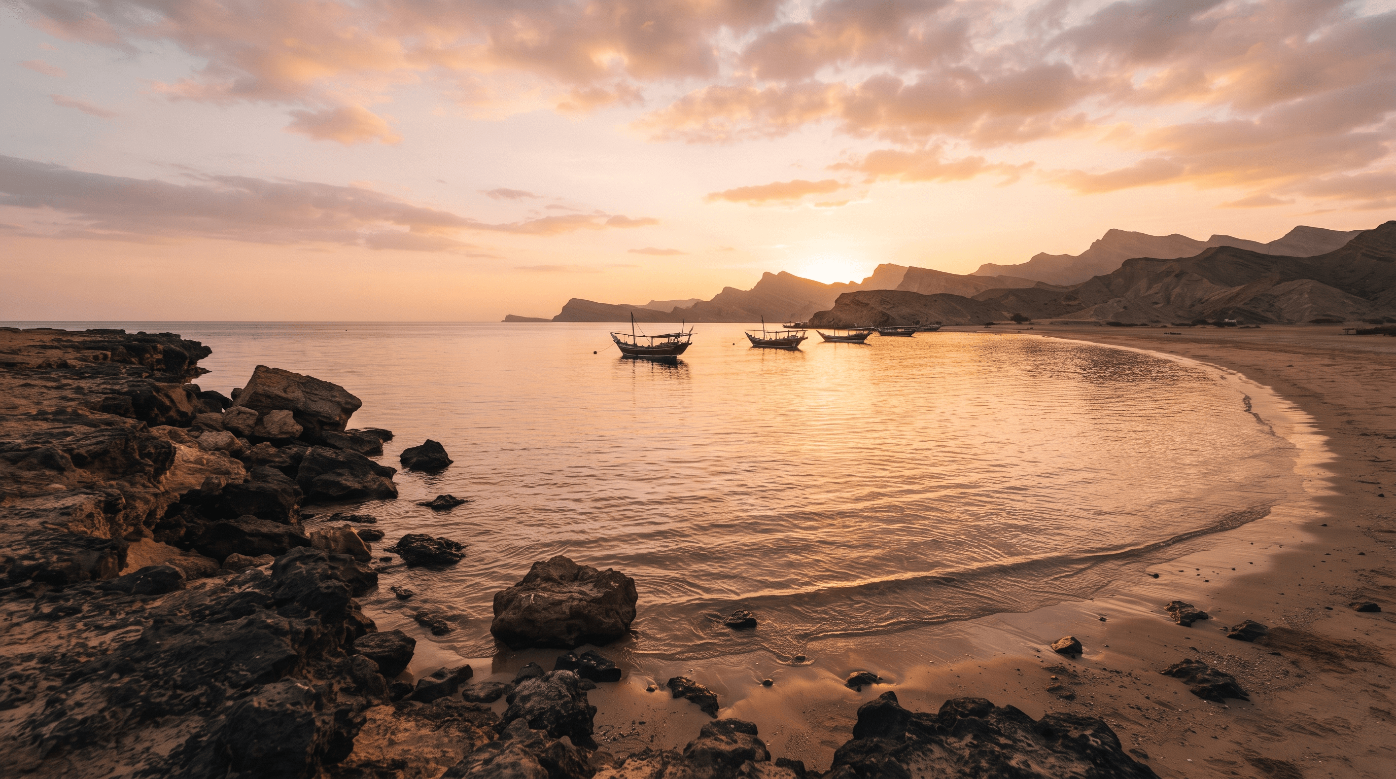 Calm Sea of Cortez at golden hour with volcanic rocks, sandy shore, and small fishing boats reflected in still warm water near Rocky Point Mexico